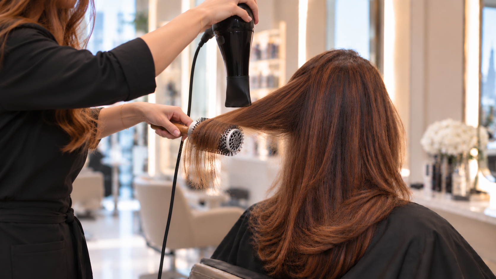 Female client receiving a professional blow-dry and hairstyling service at a salon in Dubai